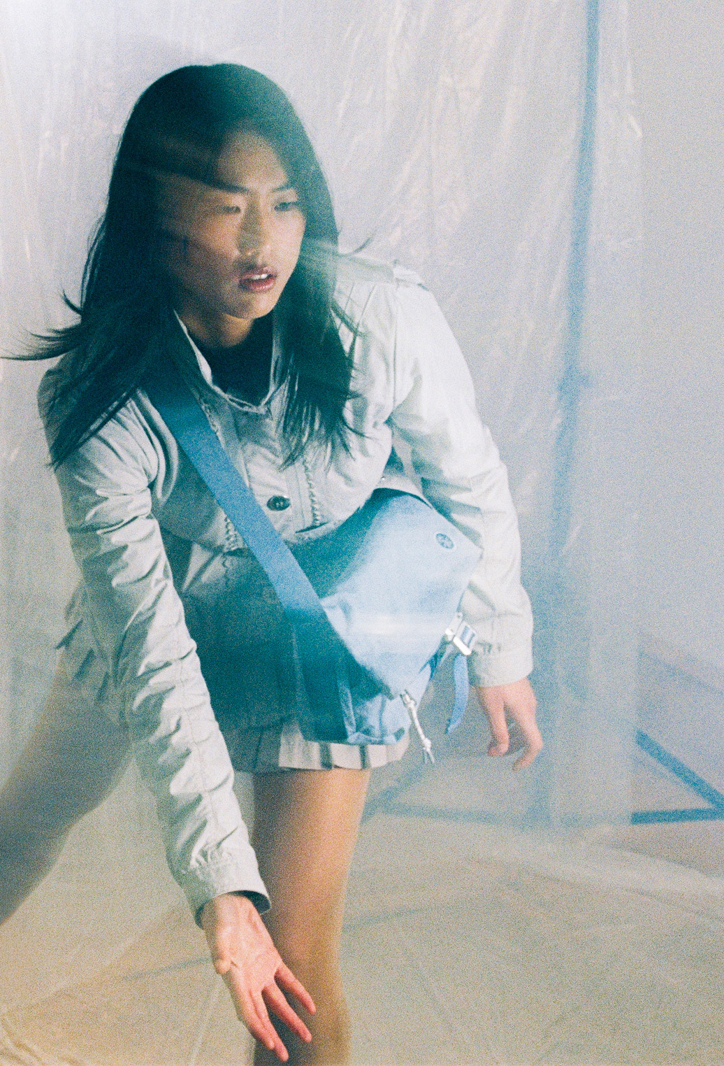 Model in white jacket with blue crossbody KONBU bag